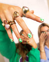 girl posing with hand in front of camera wearing nails with green and blue checkered nail art gel nail stickers